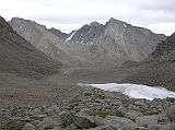 Tibet Kailash 09 Kora 11 Eastern Valley Descending from Dolma La It took us 60 minutes to trek from the D�lma La to the valley floor. As we descended from the D�lma La, we looked across to the Eastern Valley, with a tongue of glacier in our path. The peaks to the right of centre are called Tsering Chenga, the abode of five sister protectoresses, who were entrusted by Milarepa to guard Kailash.